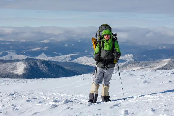 Backpacker-Mann posiert in den Winterbergen — Stockfoto