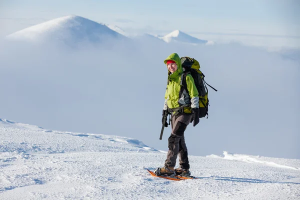 Backpacker-Frau wandert an sonnigem Tag in den Winterbergen — Stockfoto