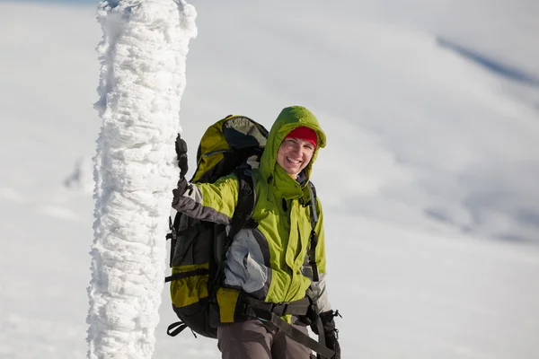Batohem žena pózuje v zimních horách — Stock fotografie