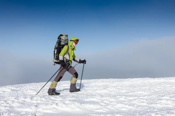 Backpacker kadın kış dağlarda güneşli günde yürüyor — Stok fotoğraf