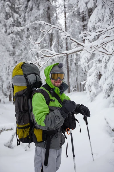 Mochilero hombre está posando en las montañas de invierno —  Fotos de Stock