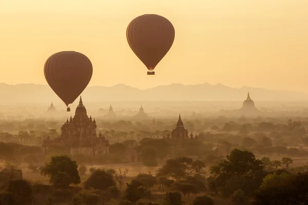 Lucht ballonnen over boeddhistische tempels bij zonsopgang. Bagan, Myanmar. — Stockfoto