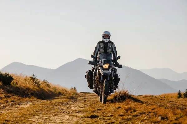 Motorbiker travelling in autumn mountains — Stock Photo, Image