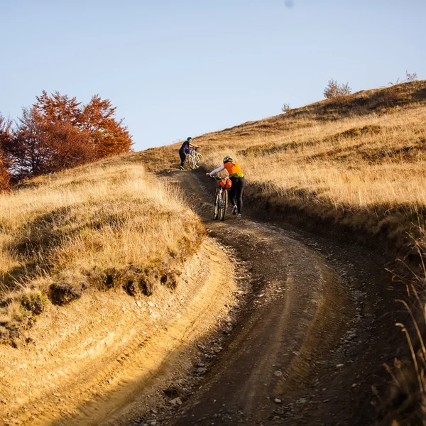 Rowerzysta jadąc w góry jesień — Zdjęcie stockowe