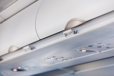 Bagaj kabukları içinde yolcu uçak koltuk numaraları ile