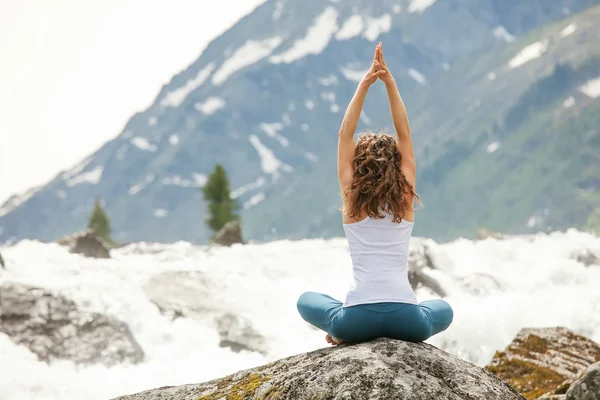 Ung kvinna utövar yoga på berget floden — Stockfoto