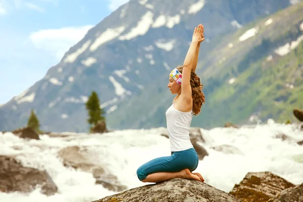 Ung kvinna utövar yoga på berget floden — Stockfoto
