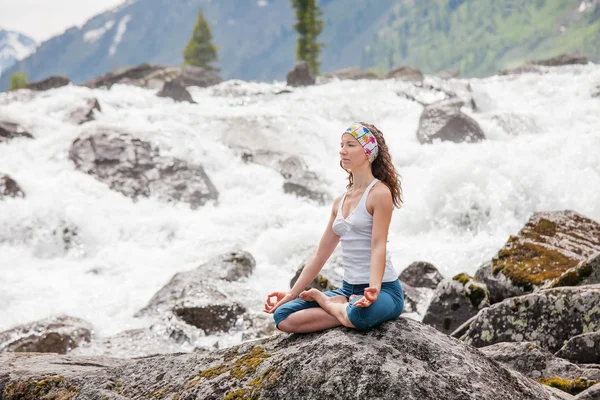 Ung kvinna utövar yoga på berget floden — Stockfoto