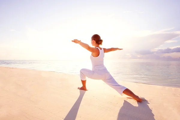 Mujer caucásica practicando yoga en la orilla del mar — Foto de Stock