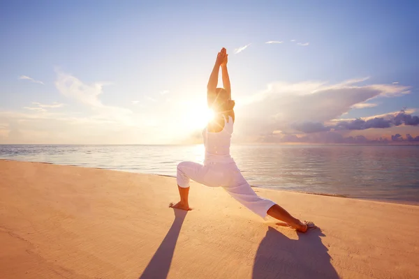 Mujer caucásica practicando yoga en la orilla del mar — Foto de Stock
