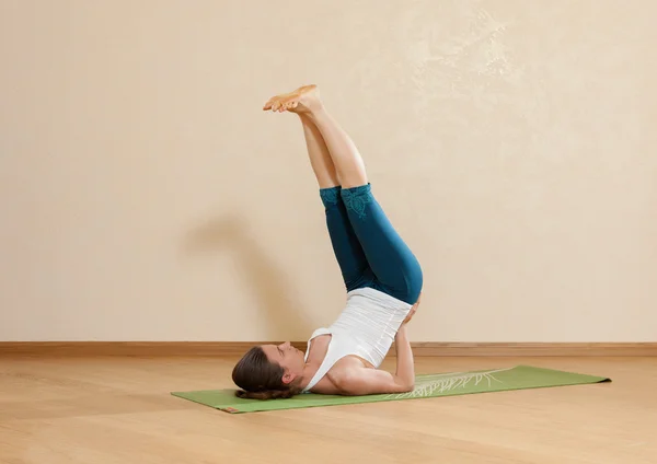 Femme caucasienne pratique le yoga en studio (sahaja sarvangasan — Photo