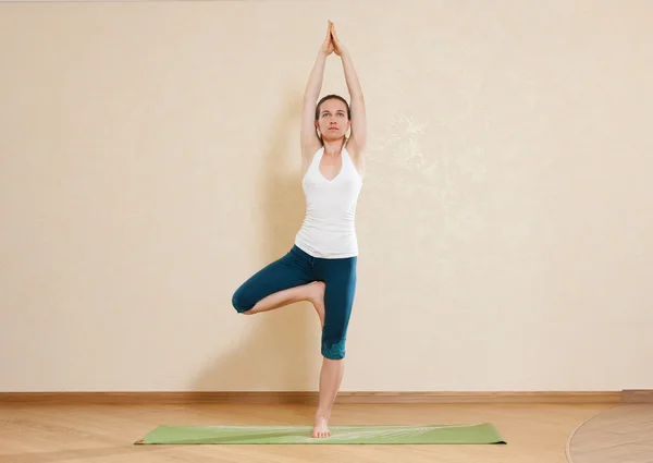 Caucasian woman is practicing yoga at studio (vrikshasana) — Stock Photo, Image