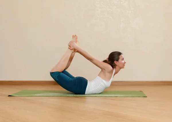 Caucasian woman is practicing yoga at studio (dhanurasana) — Stock Photo, Image