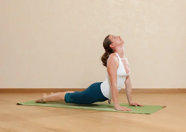 Caucasian woman is practicing yoga at studio (urdkhva mukkha shv — Stock Photo, Image