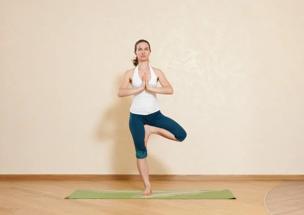 Caucasian woman is practicing yoga at studio (vrikshasana) — Stock Photo, Image