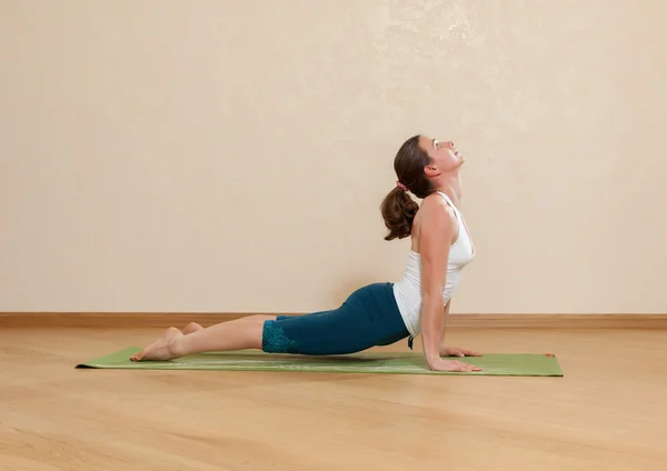 Caucasian woman is practicing yoga at studio (urdkhva mukkha shv — Stock Photo, Image