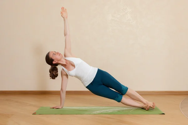 Caucasian woman is practicing yoga at studio (vasishtkhasana) — Stock Photo, Image