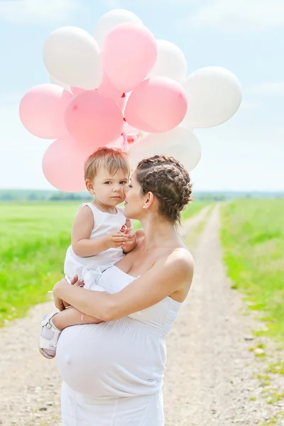 Mãe grávida e sua filha se divertir ao ar livre — Fotografia de Stock