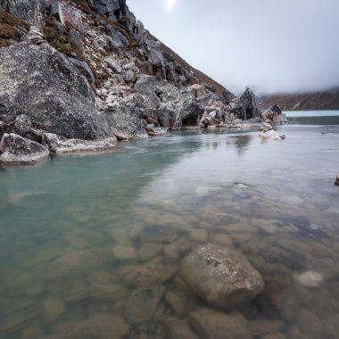 Bulutlu bir günde dağların arasında yeşil göl