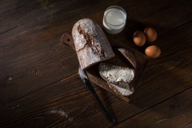 Tereyağı ve yumurta içinde alçak-ışık arpacık woodent masada ekmek