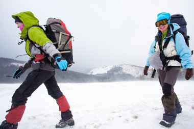 Kış dağlarında yürüyüş yapan
