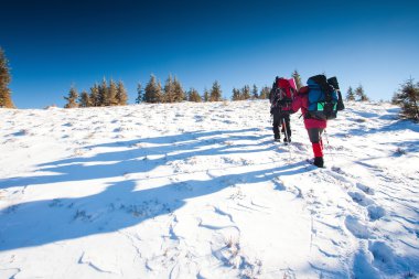 Kış dağlarında yürüyüş yapan
