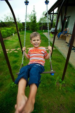Küçük beyaz çocuk eğlenceli salıncak açık vardır.
