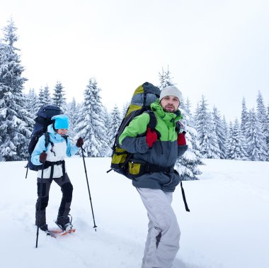 uzun yürüyüşe çıkan kimse kar ormanda yürür