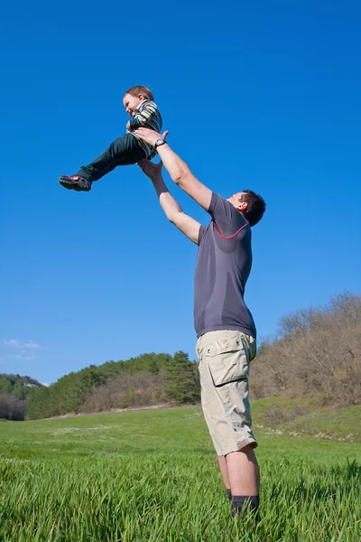 Far är att leka med sonen 1,5 år på ängen — Stockfoto
