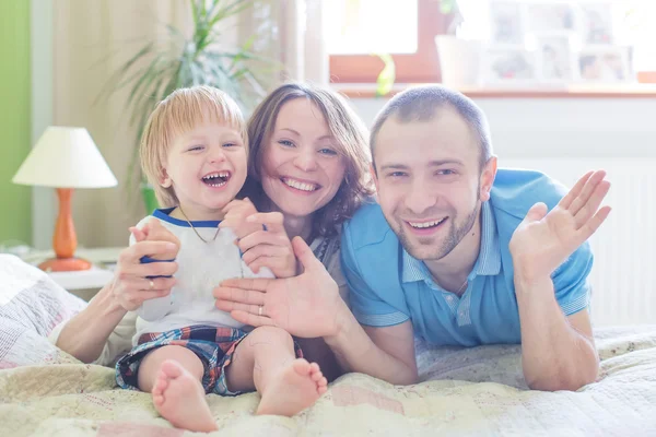 Jóvenes padres atractivos y retrato infantil en interiores — Foto de Stock