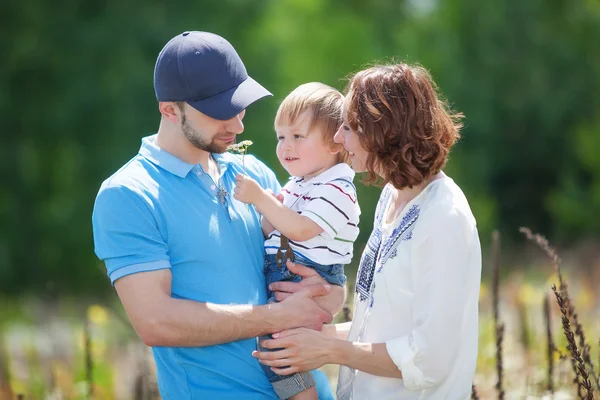 Jóvenes padres atractivos y retrato infantil al aire libre — Foto de Stock