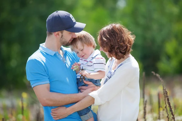 Jóvenes padres atractivos y retrato infantil al aire libre — Foto de Stock