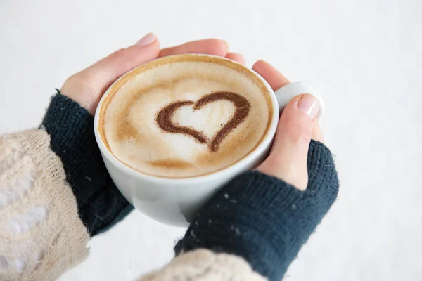 Femme tenant tasse chaude de café, avec la forme du cœur — Photo