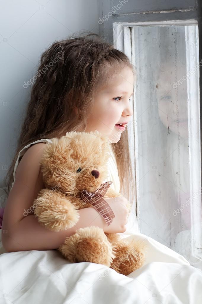 Girl with teddy bear in hand