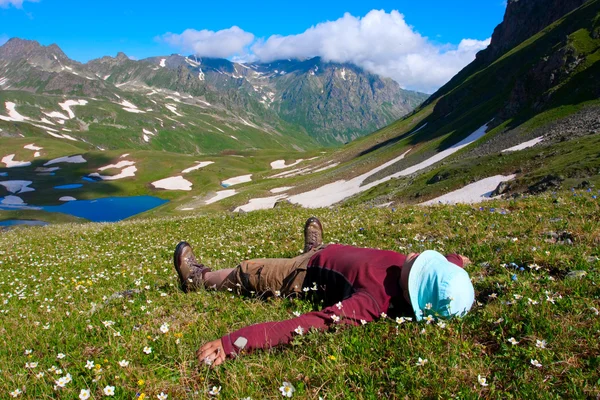 Uzun yürüyüşe çıkan kimse dağ çayır üzerinde yatıyor — Stok fotoğraf