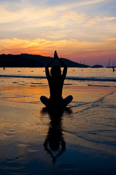 Silhouette di una donna che medita vicino al mare — Foto Stock