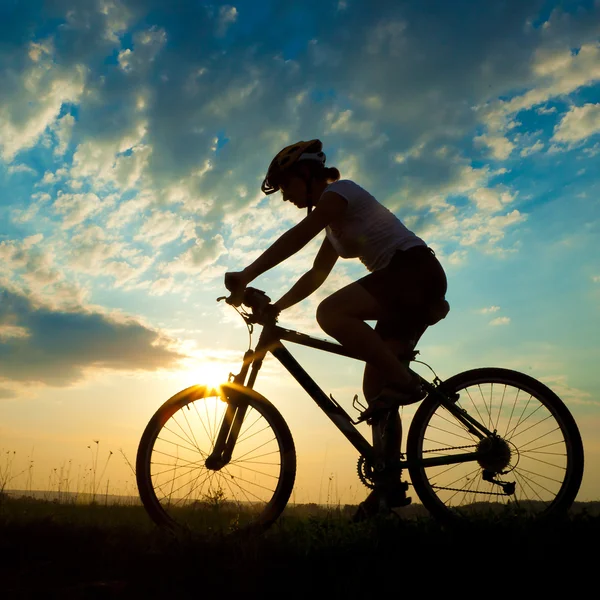 Motociclista al atardecer en el prado —  Fotos de Stock