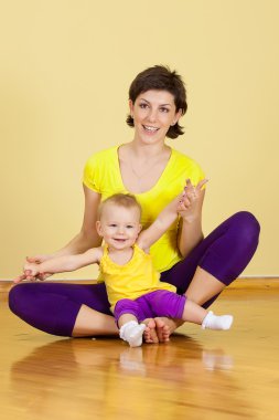 Annenin bebeği ile birlikte fitness egzersizleri yaptığı