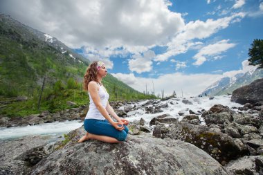 Genç kadın dağ nehir, yoga uygulamak
