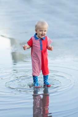 Küçük çocuk su birikintileri çalışan