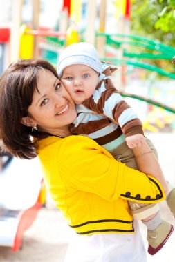 Mutlu bir aile. Anne ve bebek oğlu parkta oynarken