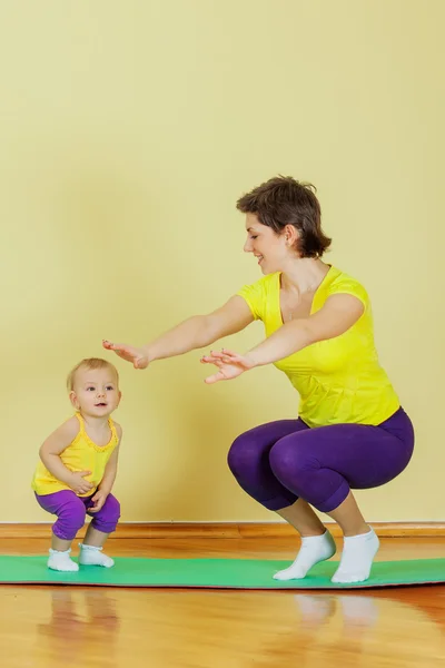 Mother do phisical exercises with her daughter at home — Stock Photo, Image