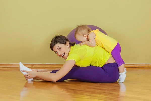 Mãe faz exercícios físicos com a filha em casa — Fotografia de Stock