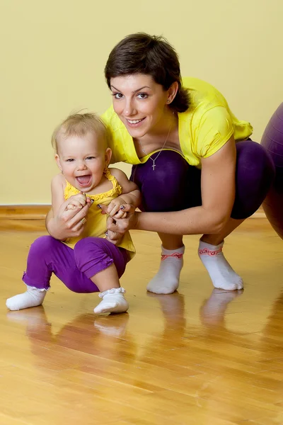 Mãe faz exercícios de fitness junto com seu bebê — Fotografia de Stock