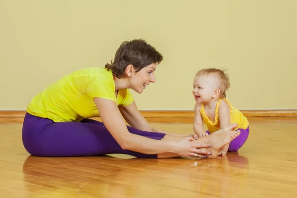 Madre hace ejercicios físicos con su hija en casa — Foto de Stock