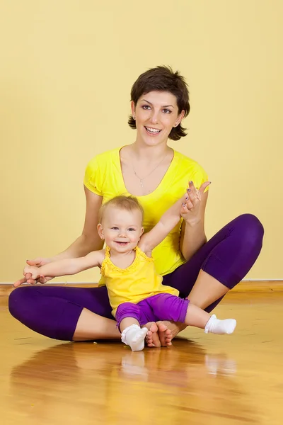 Mãe faz exercícios de fitness junto com seu bebê — Fotografia de Stock