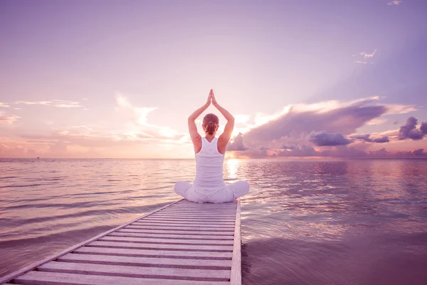 Mujer caucásica practicando yoga en la orilla del mar — Foto de Stock