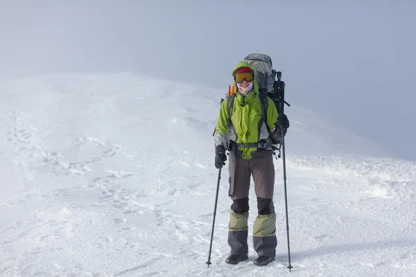 Randonneur posant à la caméra dans les montagnes d'hiver — Photo