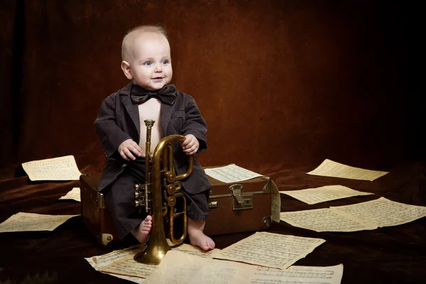 Caucasian baby boy plays with trumpet — Stock Photo, Image