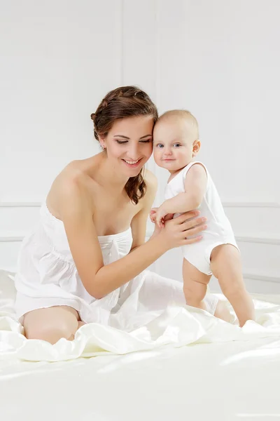 Familia feliz. Madre y su hijo jugando y sonriendo en la cama — Foto de Stock